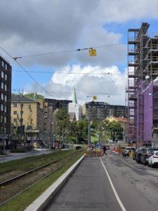 Author's photo of a perspective on Gothenburg, including tram lines alongside a road and buildings on either side, one of which is scaffolded.